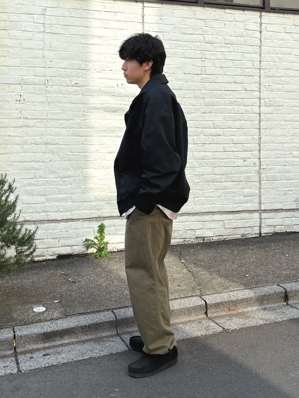 ブラック系のナイロンジャケット、ピンク系のシャツ/ブラウス、グリーン系のカーゴパンツを着用したメンズの春コーディネートの2枚目の写真