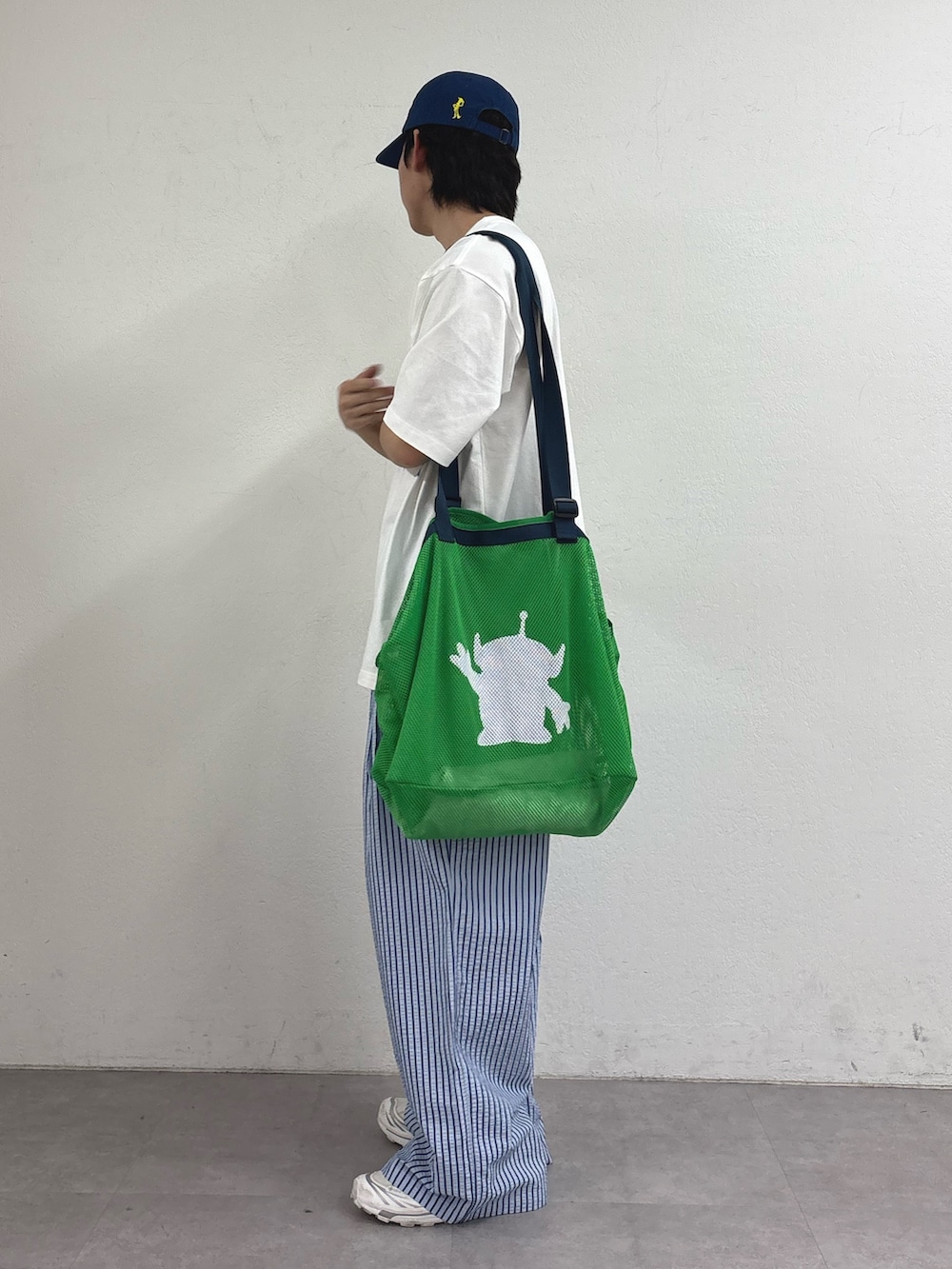 グリーン系のトートバッグ、ホワイト系のTシャツ/カットソー、ブルー系のその他パンツを着用したメンズの春コーディネートの2枚目の写真
