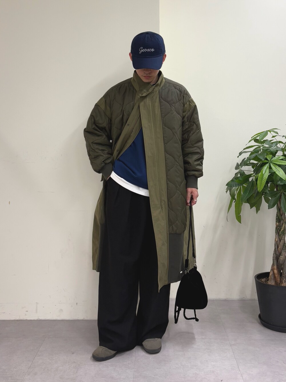 ブルー系のスウェット、グリーン系のモッズコート、ブラック系のスラックスを着用したメンズの春コーディネートの3枚目の写真