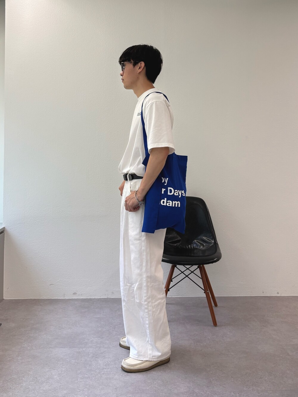 ホワイト系のデニムパンツ、ホワイト系のTシャツ/カットソー、ブルー系のトートバッグを着用したメンズの夏コーディネートの2枚目の写真