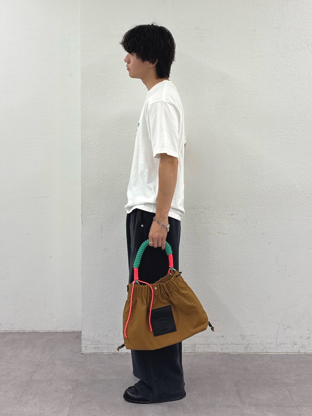 ホワイト系のTシャツ/カットソー、ブラック系のスウェットパンツ、イエロー系のトートバッグを着用したメンズの夏コーディネートの2枚目の写真