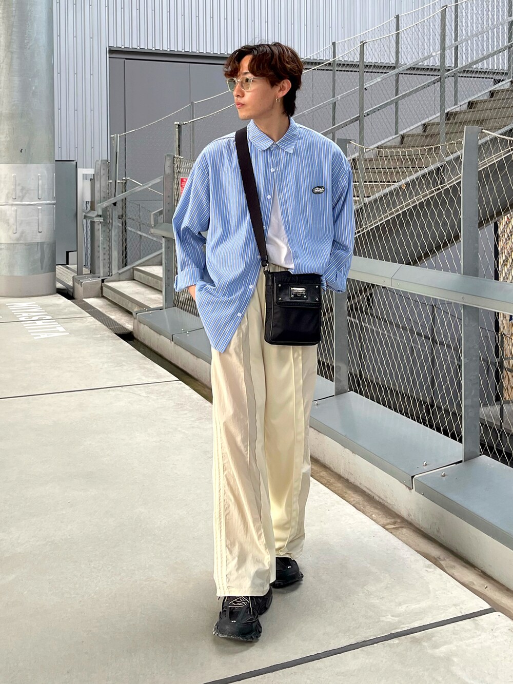 ブラック系のスニーカー、ホワイト系のスウェットパンツ、ブラック系のバッグを着用したメンズの夏コーディネートの2枚目の写真