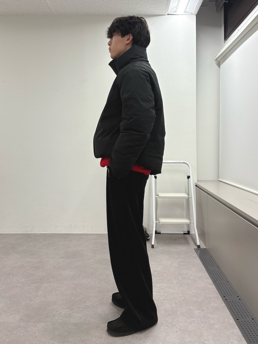 ブラック系のダウンジャケット/コート、レッド系のニット/セーター、ブラック系のその他パンツを着用したメンズの冬コーディネートの2枚目の写真