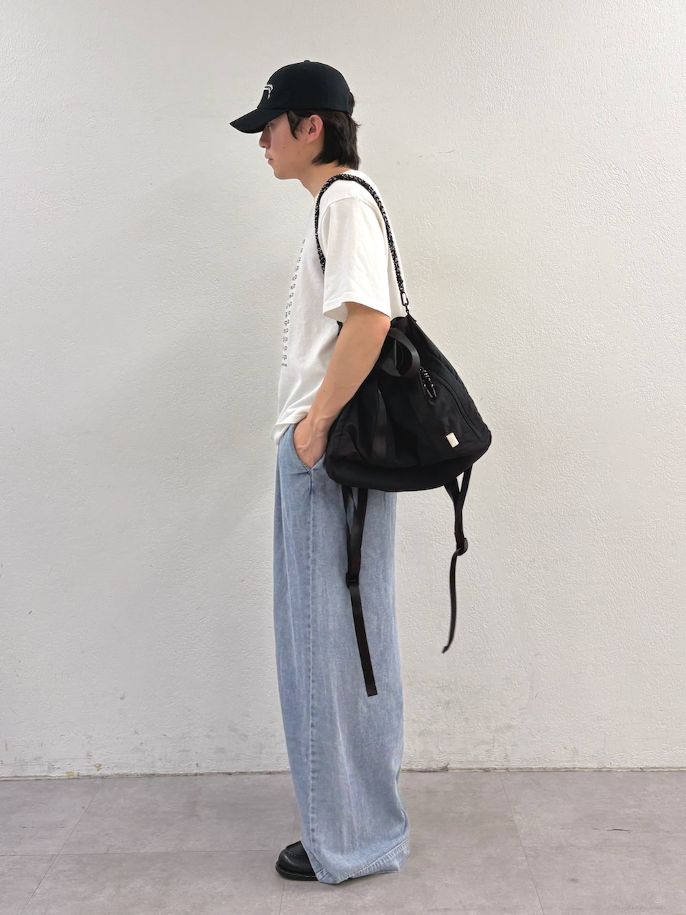 ホワイト系のTシャツ/カットソー、ブラック系のトートバッグ、ブルー系のデニムパンツを着用したメンズの春コーディネートの2枚目の写真