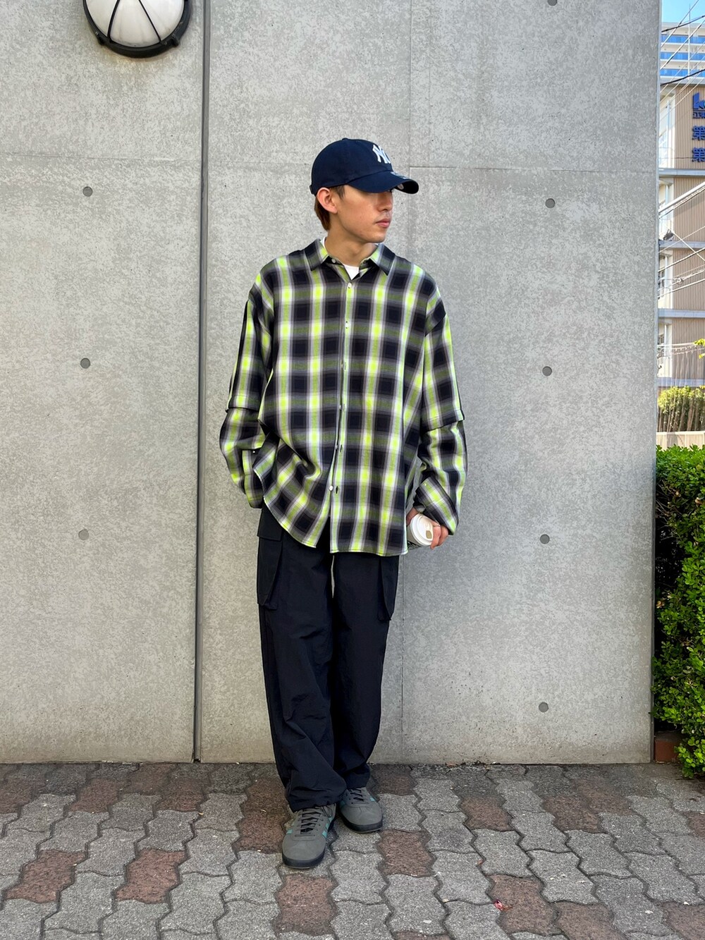 イエロー系のシャツ/ブラウス、ブラック系のカーゴパンツ、グレー系のスニーカーを着用したメンズの秋コーディネートの2枚目の写真