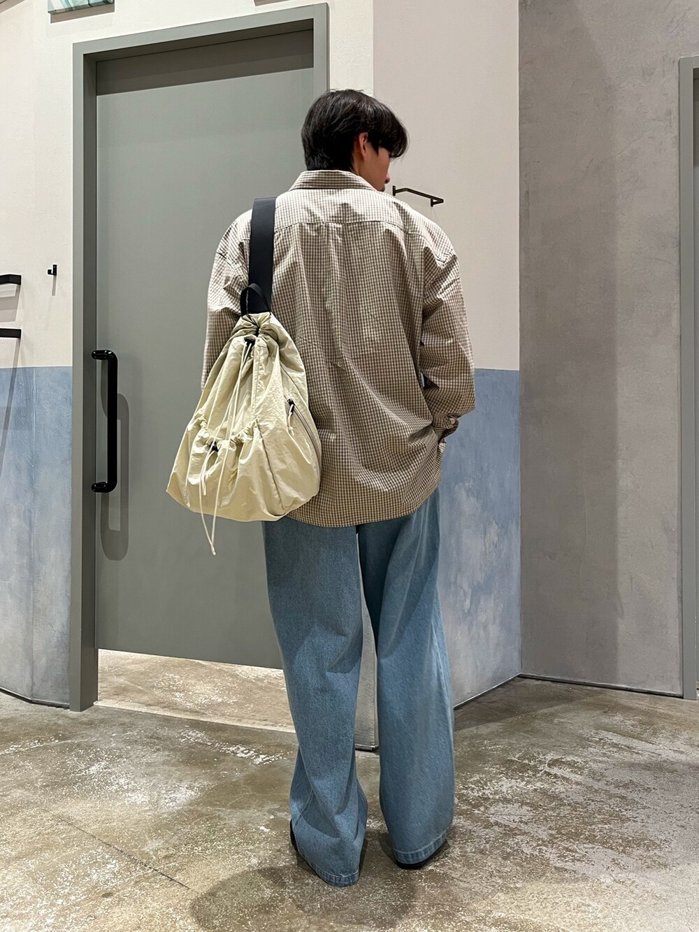 ブラック系のスニーカー、ブルー系のデニムパンツ、ベージュ系のシャツ/ブラウスを着用したメンズの春コーディネートの3枚目の写真