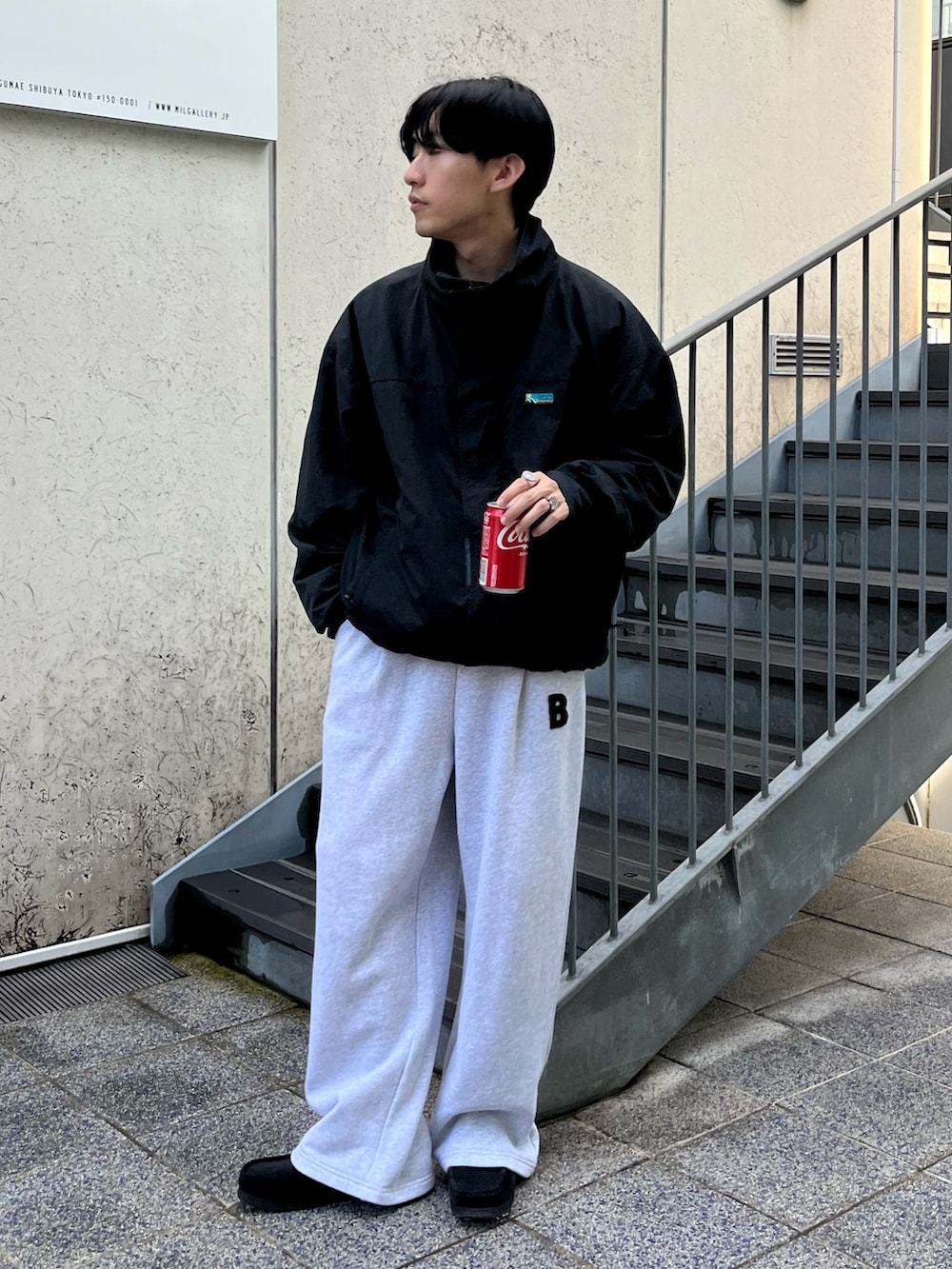 ブラック系のナイロンジャケット、グレー系のスウェットパンツ、ブラック系のスニーカーを着用したメンズの秋コーディネートの2枚目の写真