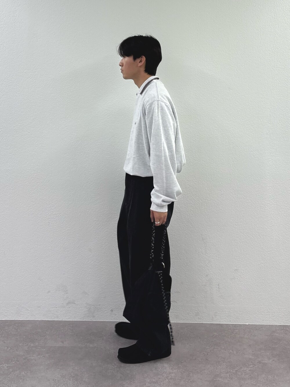 グレー系のスウェット、ブラック系のデニムパンツを着用したメンズの秋コーディネートの2枚目の写真