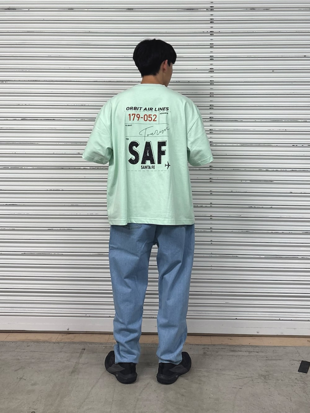 グリーン系のTシャツ/カットソー、ブルー系のデニムパンツを着用したメンズの春コーディネートの2枚目の写真