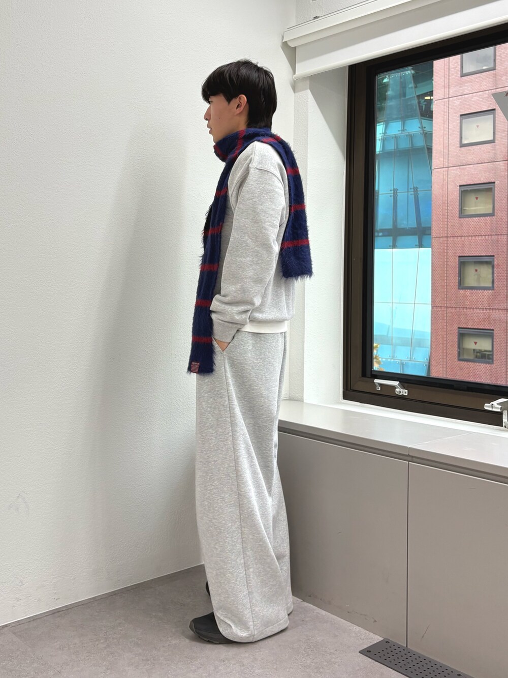 グレー系のスウェット、グレー系のその他パンツ、ブルー系のマフラーを着用したメンズの秋コーディネートの2枚目の写真