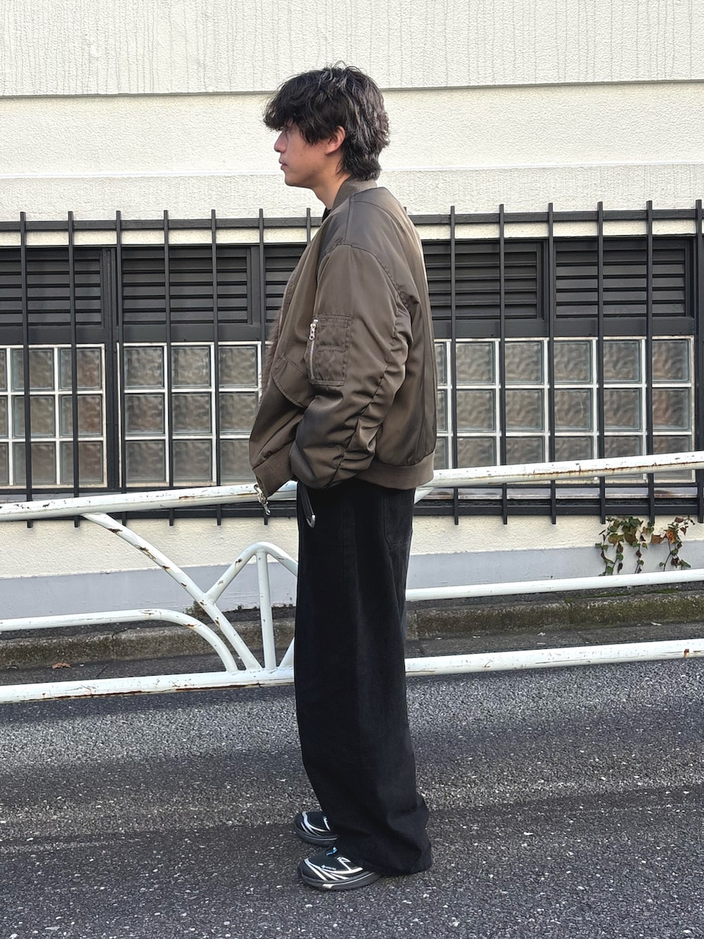 グリーン系のMA-1、ブラック系のTシャツ/カットソー、ブラック系のデニムパンツを着用したメンズの秋コーディネートの2枚目の写真