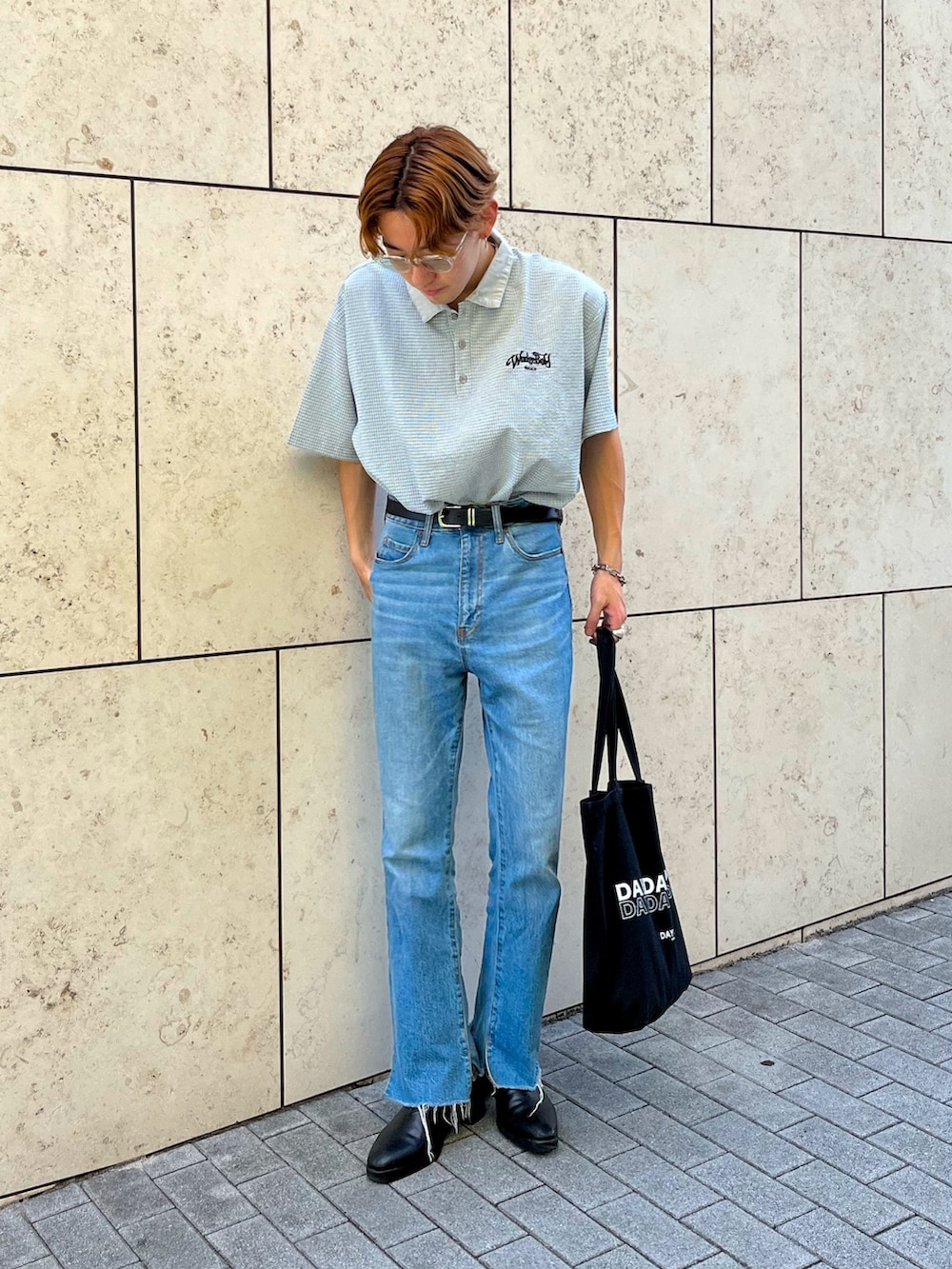 ブルー系のデニムパンツ、ブラック系のブーツ、ブラック系のトートバッグを着用したメンズの夏コーディネートの3枚目の写真