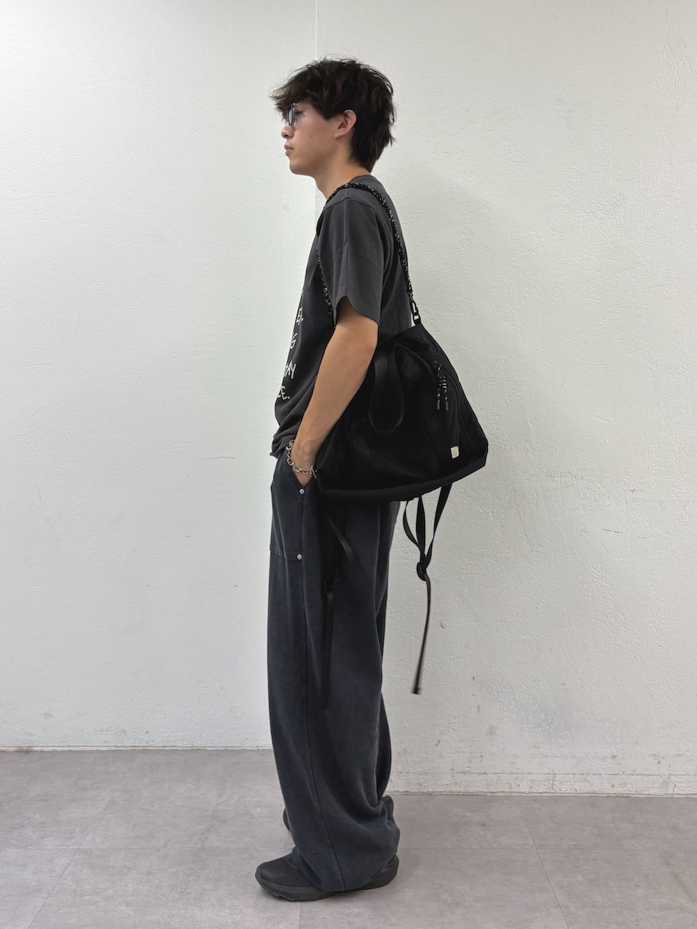 ブラック系のTシャツ/カットソー、ブラック系のトートバッグ、ブラック系のスウェットパンツを着用したメンズの夏コーディネートの2枚目の写真