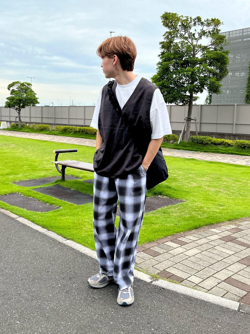 グレー系のスニーカー、ブラック系のその他パンツ、グレー系のベストを着用したメンズの夏コーディネートの2枚目の写真