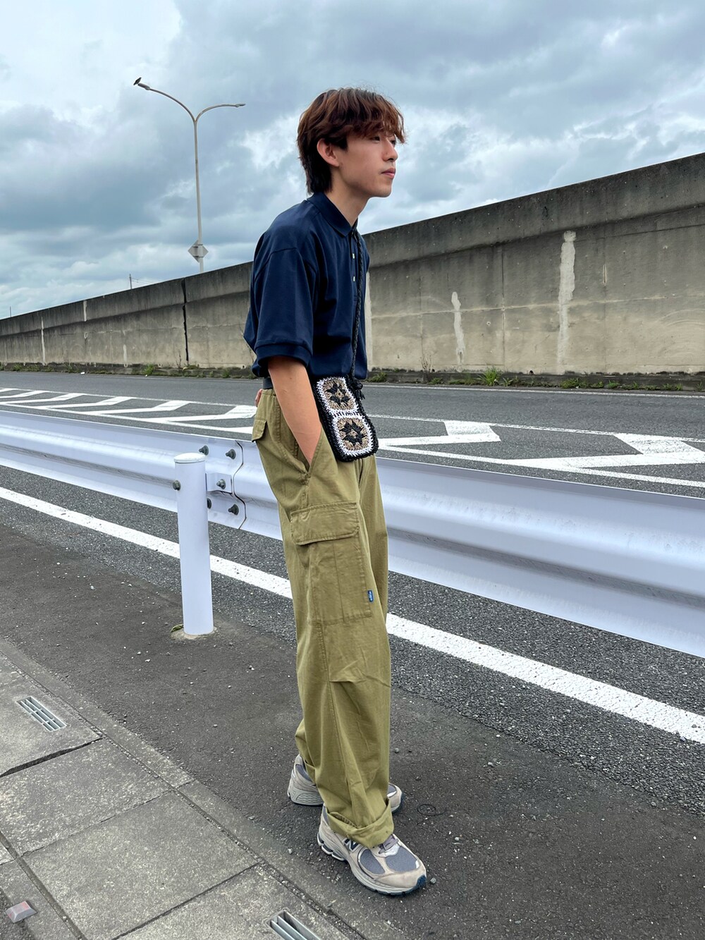 グレー系のスニーカー、グリーン系のカーゴパンツ、ブルー系のポロシャツを着用したメンズの夏コーディネートの3枚目の写真