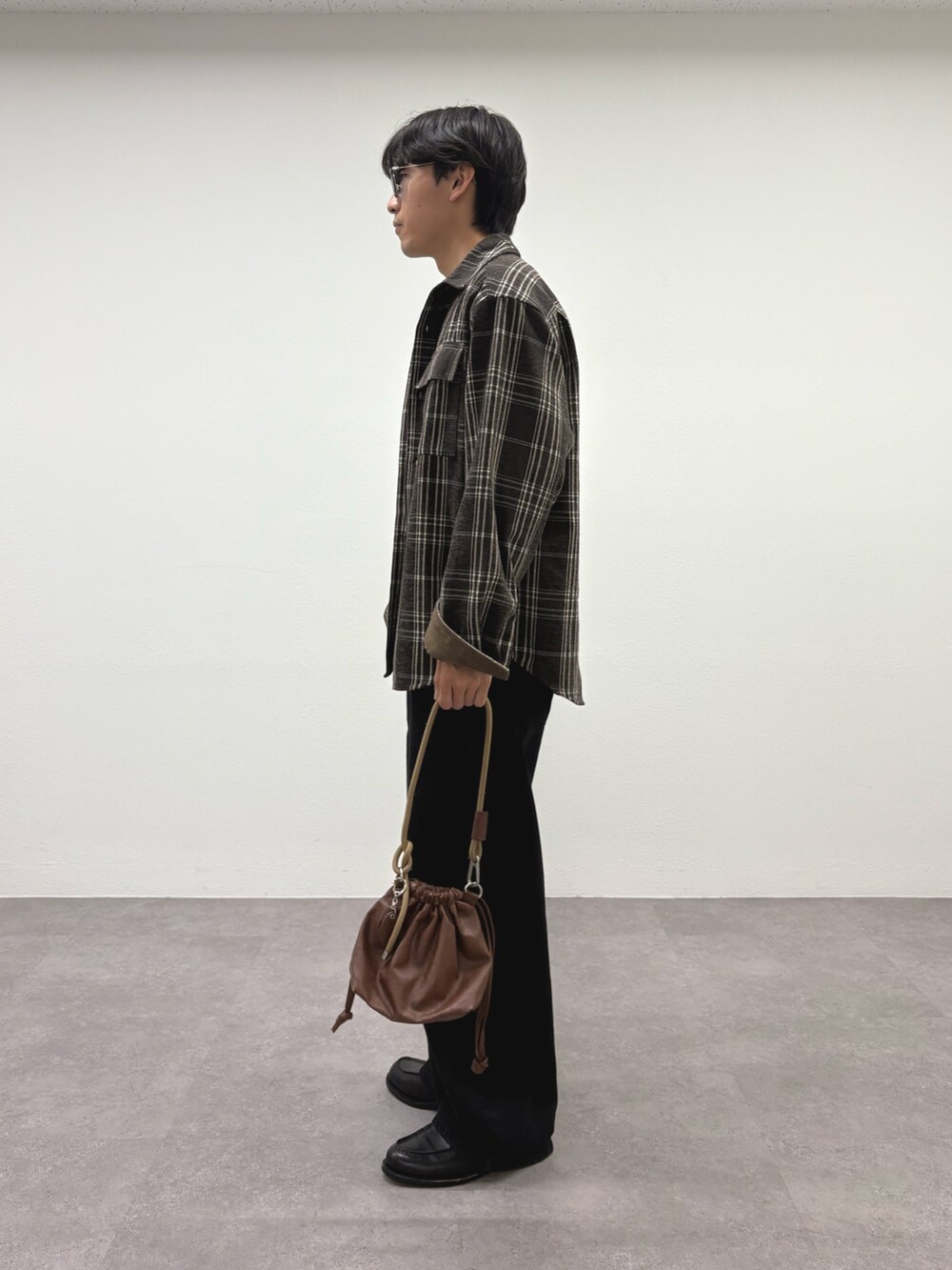 ブラウン系のシャツ/ブラウス、ホワイト系のTシャツ/カットソー、ブラック系のデニムパンツを着用したメンズの秋コーディネートの2枚目の写真