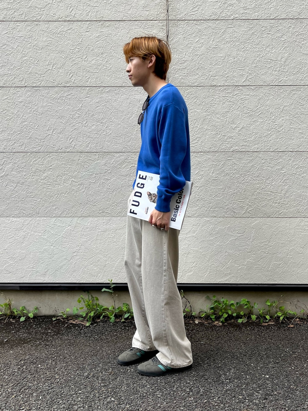 グレー系のスニーカー、グレー系のパンツ、ブルー系のニット/セーターを着用したメンズの秋コーディネートの2枚目の写真