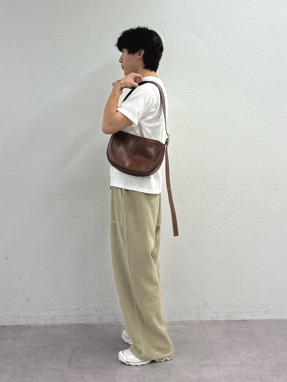 ホワイト系のTシャツ/カットソー、ブラウン系のショルダーバッグ、ベージュ系のスウェットパンツを着用したメンズの夏コーディネートの2枚目の写真