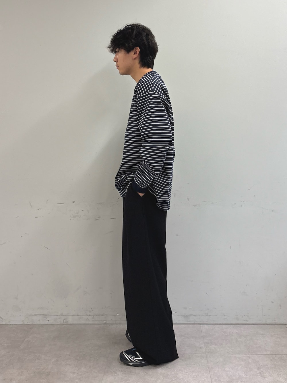 ブルー系のTシャツ/カットソー、ブラック系のスラックスを着用したメンズの秋コーディネートの2枚目の写真