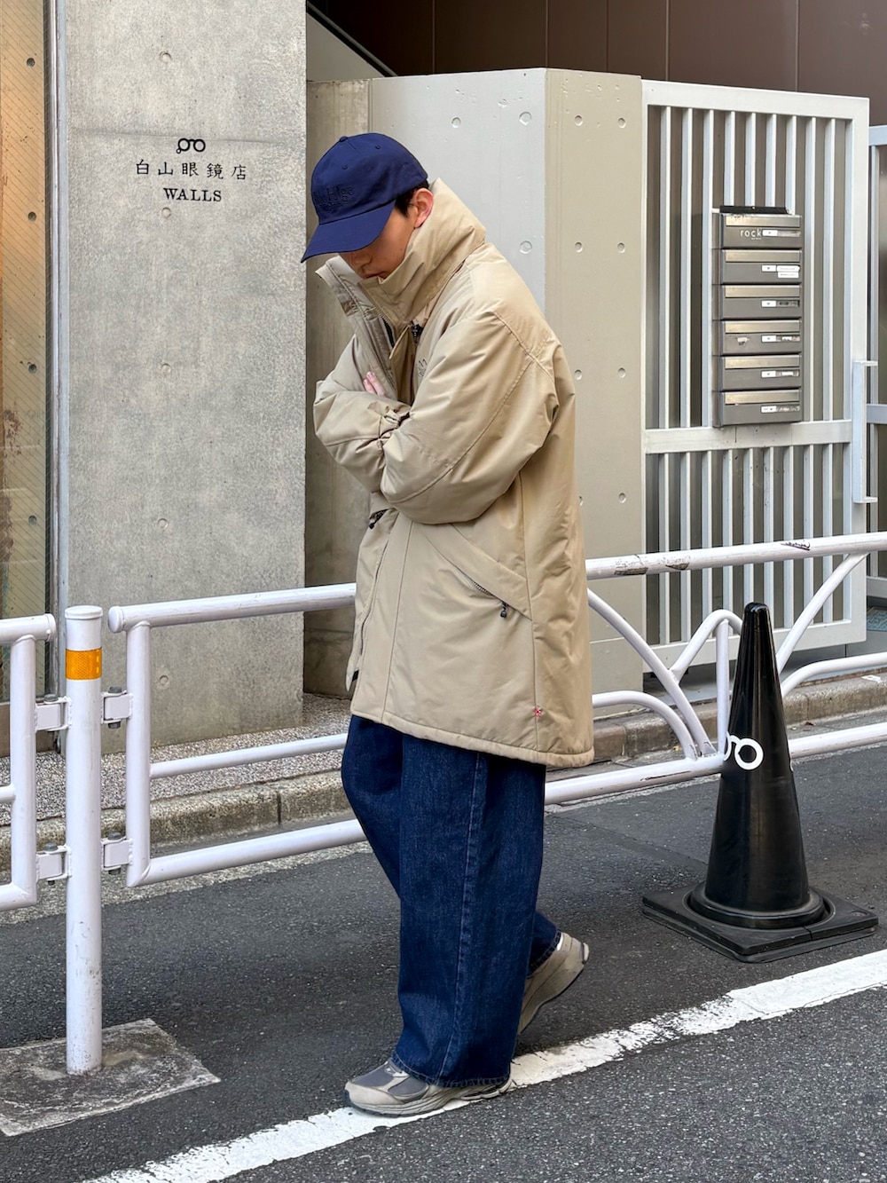 ベージュ系のダウンジャケット/コート、ブルー系のデニムパンツ、グレー系のスニーカーを着用したメンズの冬コーディネートの2枚目の写真