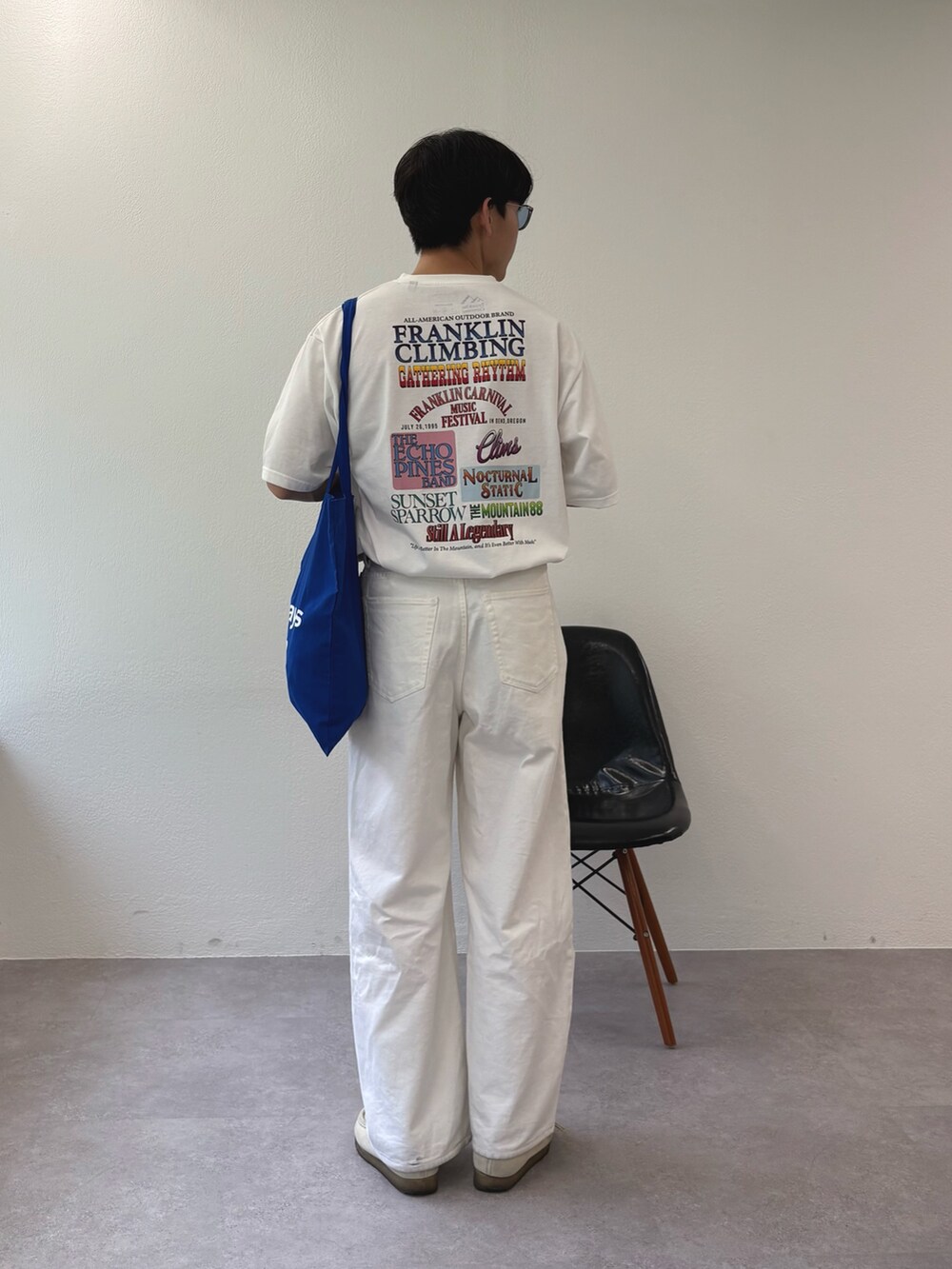 ホワイト系のデニムパンツ、ホワイト系のTシャツ/カットソー、ブルー系のトートバッグを着用したメンズの夏コーディネートの3枚目の写真