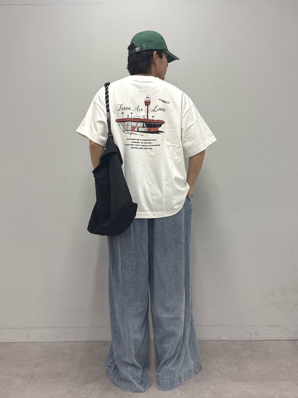 ホワイト系のTシャツ/カットソー、ブラック系のショルダーバッグ、ブルー系のデニムパンツを着用したメンズの夏コーディネートの3枚目の写真