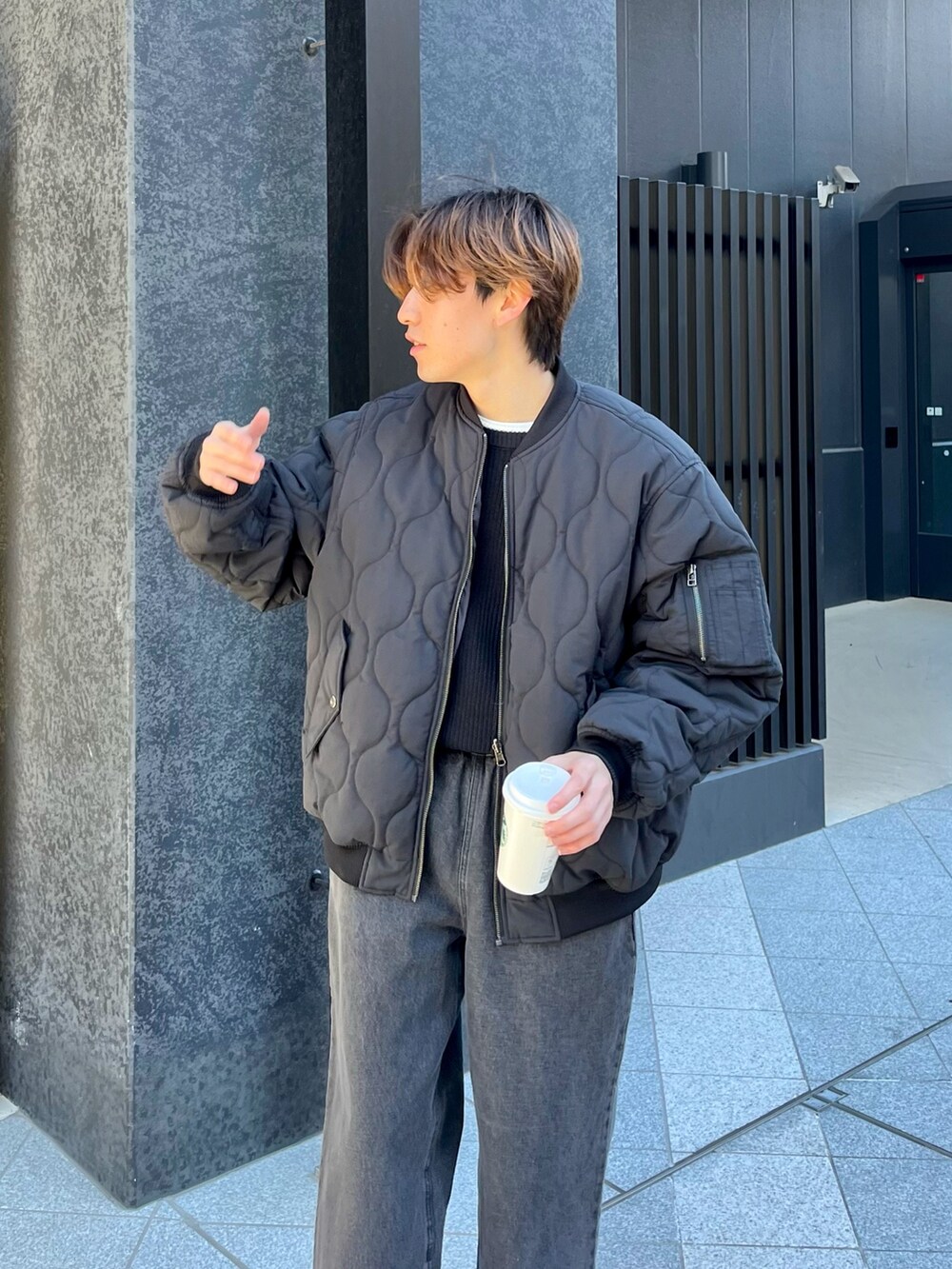 ブラック系のニット/セーター、ブラック系のMA-1、ブラック系のデニムパンツを着用したメンズの冬コーディネートの2枚目の写真