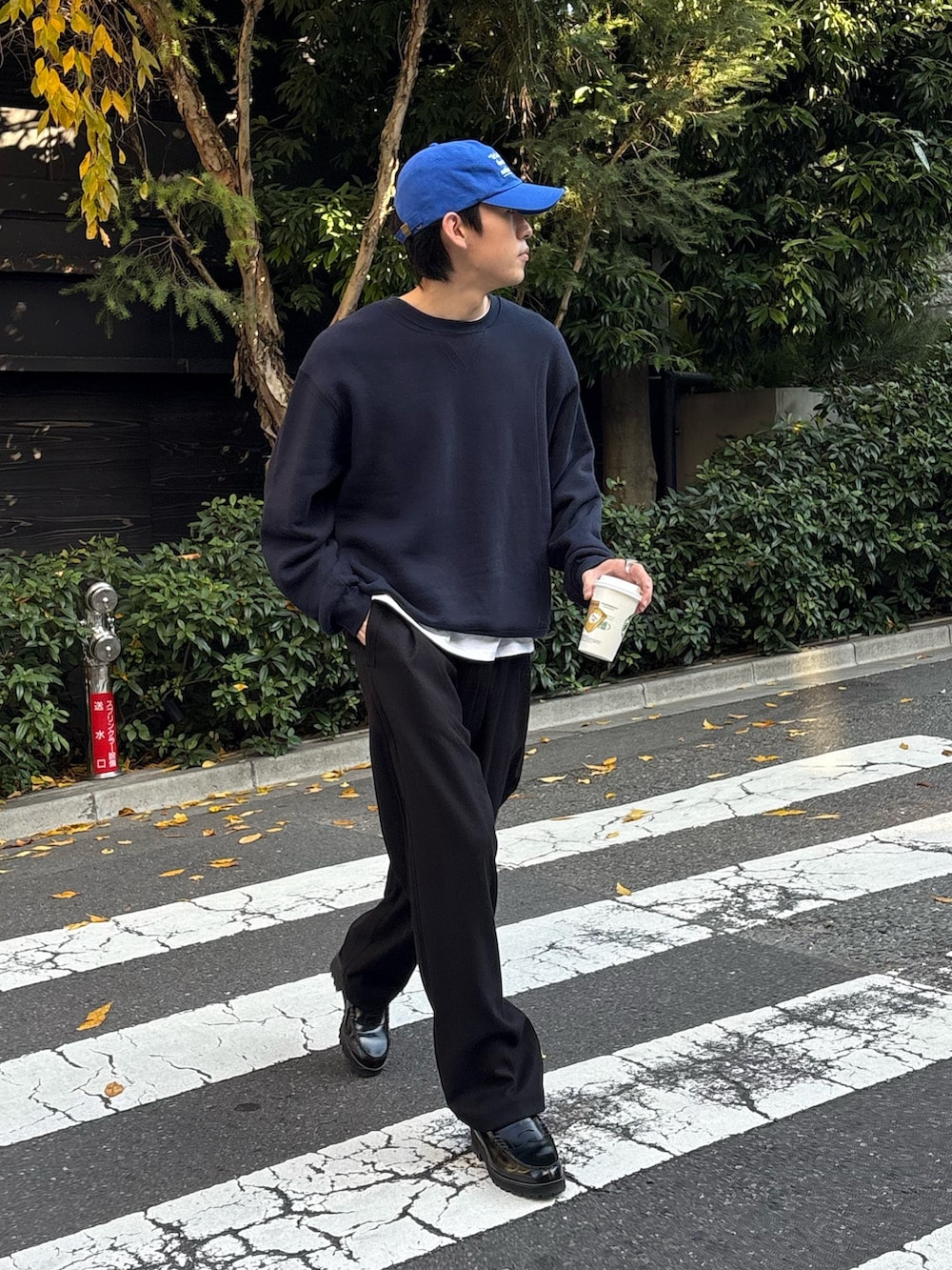 ブラック系のスラックス、ブルー系のスウェット、ブルー系のキャップを着用したメンズの冬コーディネートの3枚目の写真