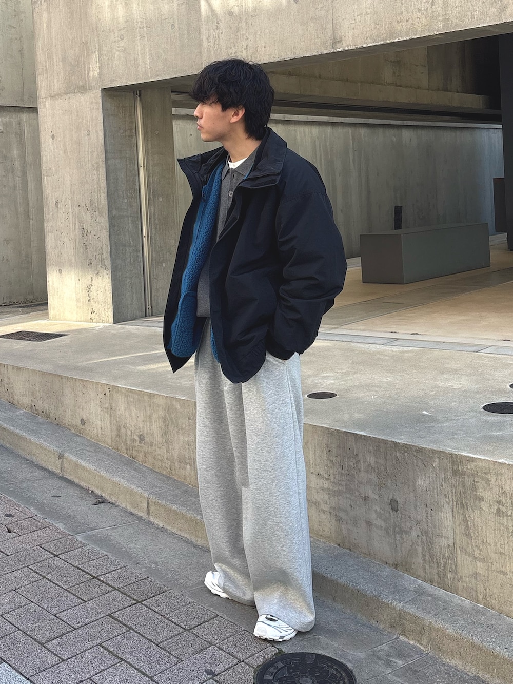ブラック系のナイロンジャケット、グレー系のニット/セーター、ブルー系のブルゾンを着用したメンズの冬コーディネートの2枚目の写真