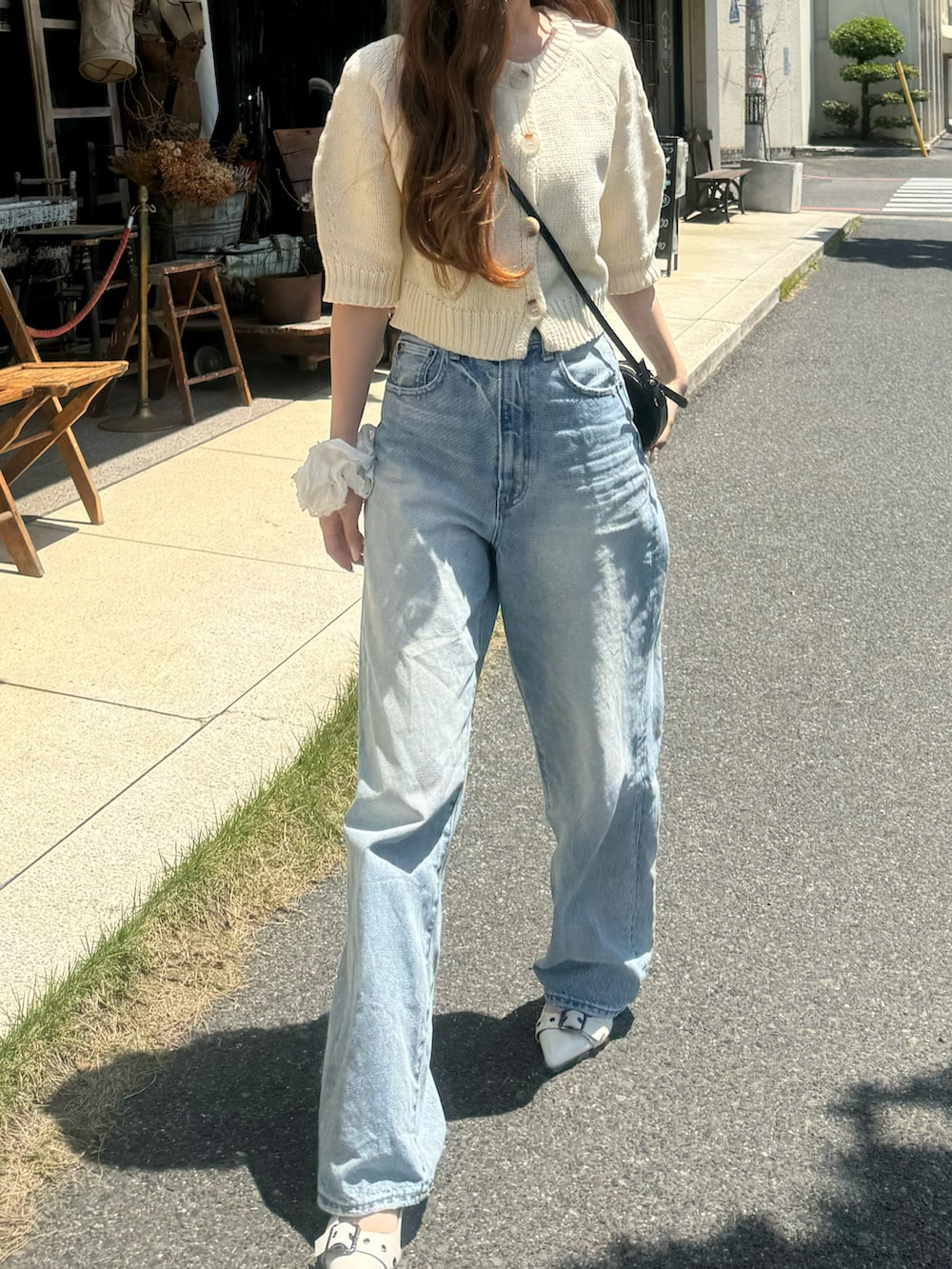 ホワイト系のニット/セーター、ブルー系のデニムパンツを着用したレディースの春コーディネートの3枚目の写真
