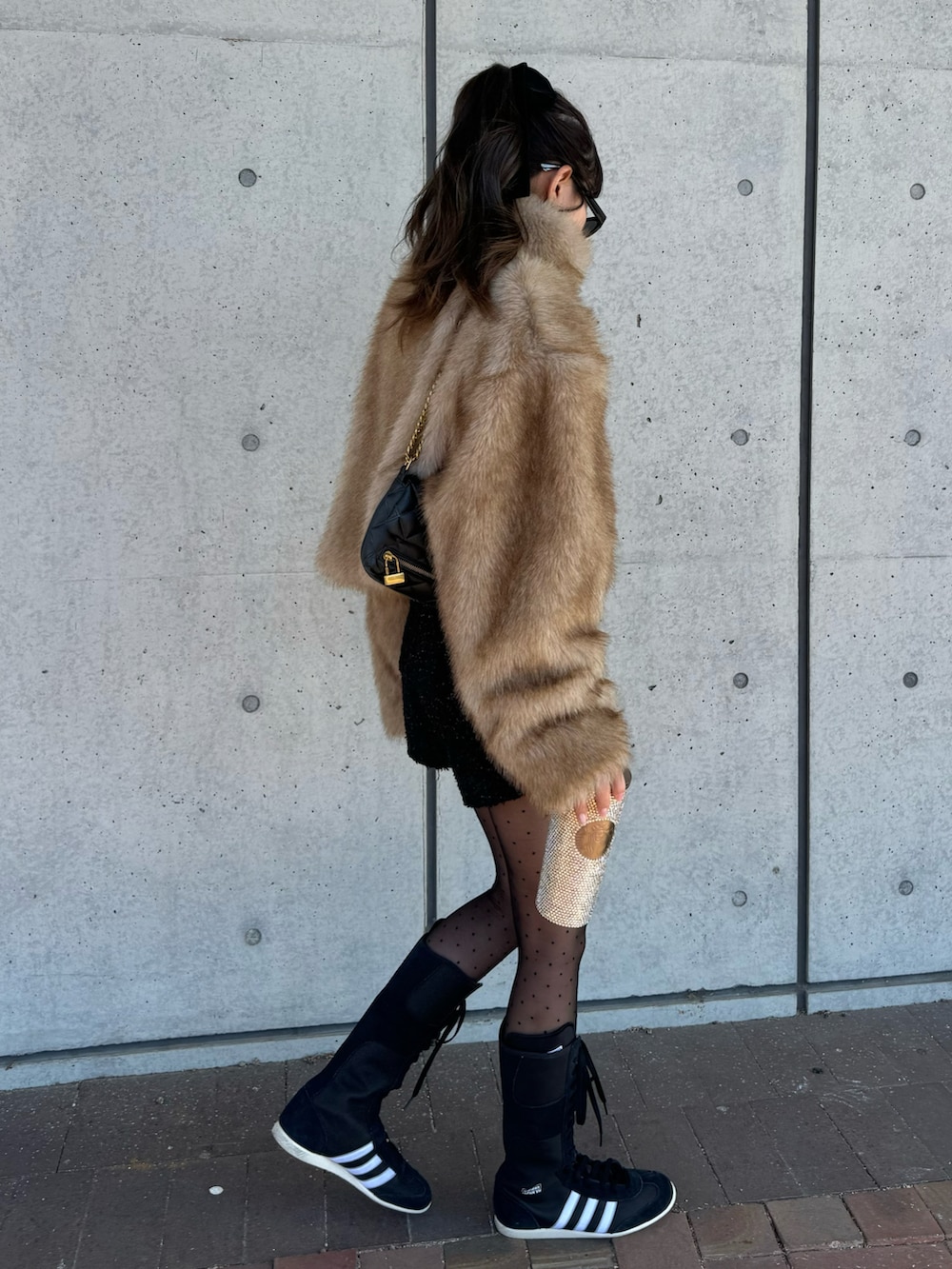 ブラウン系のブルゾン、ブラック系のパンツ、ブラック系のスニーカーを着用したレディースの冬コーディネートの2枚目の写真