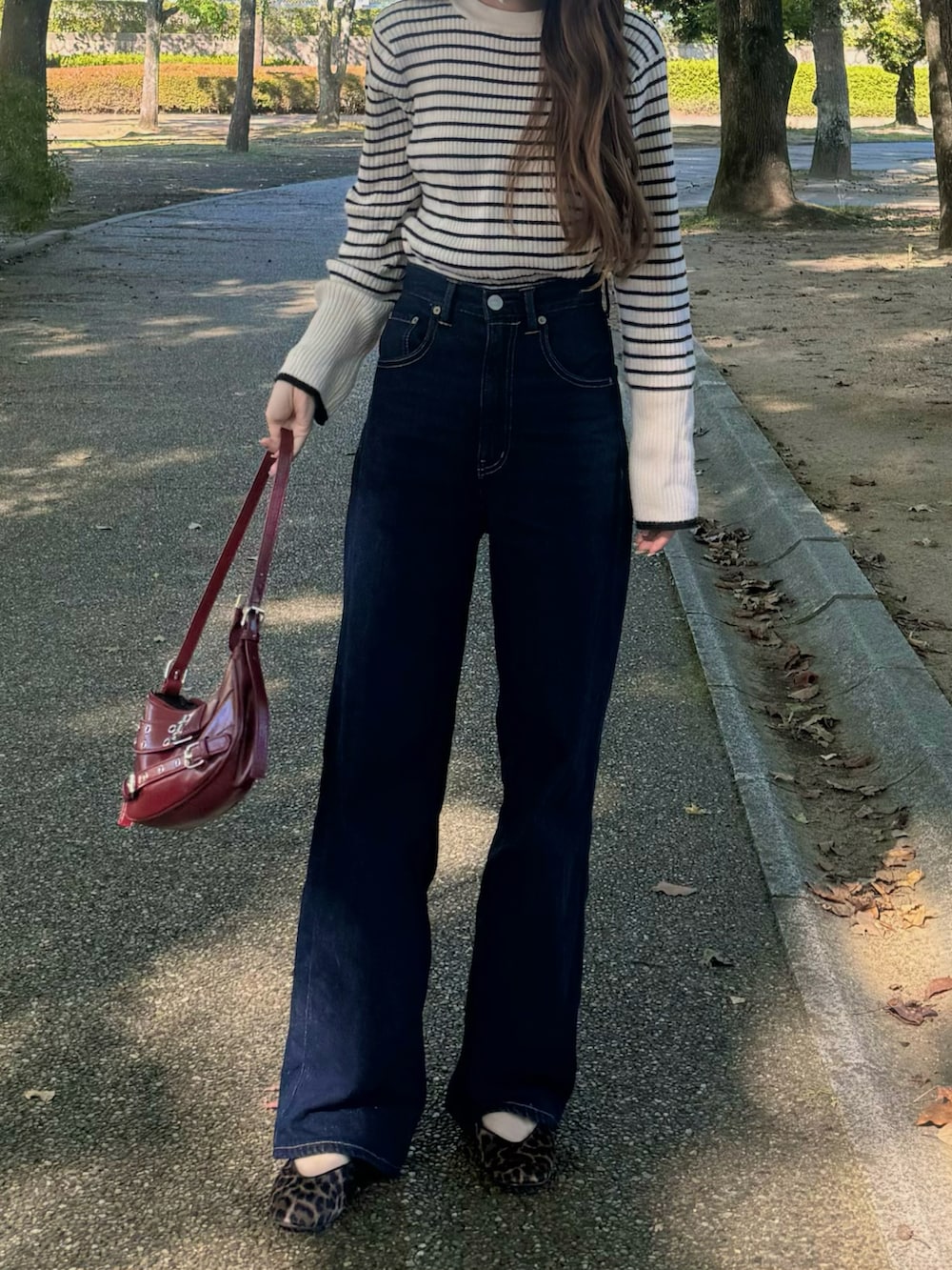 ホワイト系のニット/セーター、ブルー系のデニムパンツ、ブラウン系のバレエシューズを着用したレディースの秋コーディネートの2枚目の写真