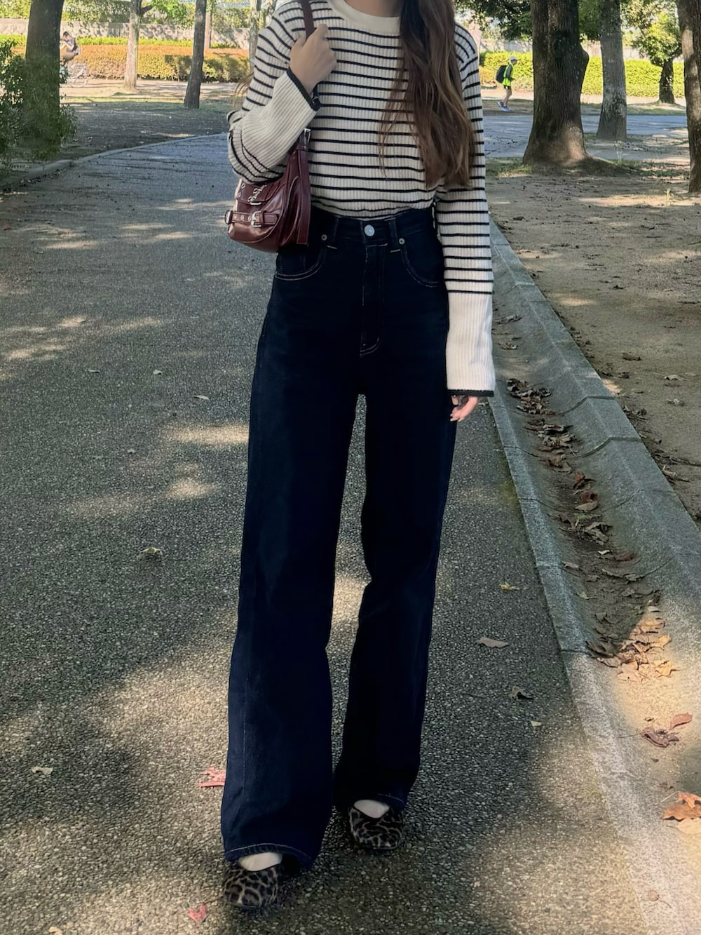 ホワイト系のニット/セーター、ブルー系のデニムパンツ、ブラウン系のバレエシューズを着用したレディースの秋コーディネートの3枚目の写真