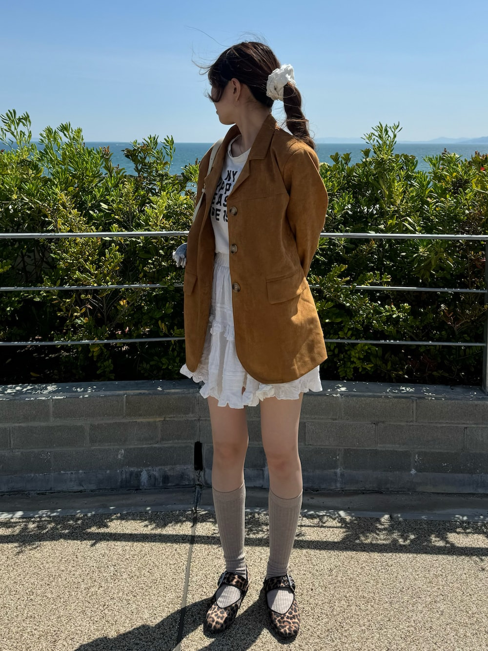 ブラウン系のジャケット/アウター、ホワイト系のスカート、ブラウン系のバレエシューズを着用したレディースの春コーディネートの2枚目の写真