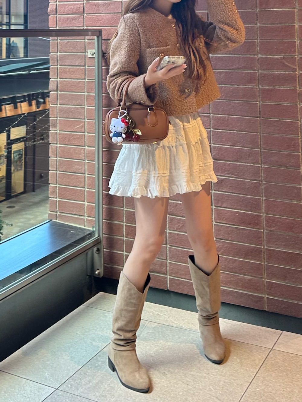 ブラウン系のジャケット/アウター、ホワイト系のスカート、ベージュ系のブーツを着用したレディースの秋コーディネートの2枚目の写真