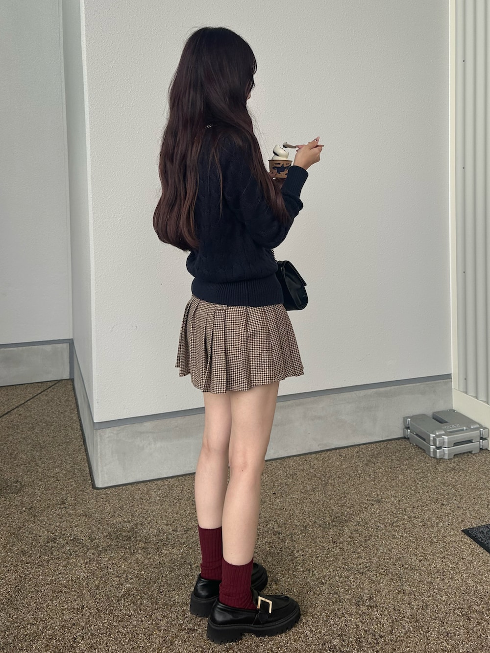 ブルー系のカーディガン/ボレロ、ブラウン系のスカート、ブラック系のローファーを着用したレディースの秋コーディネートの3枚目の写真