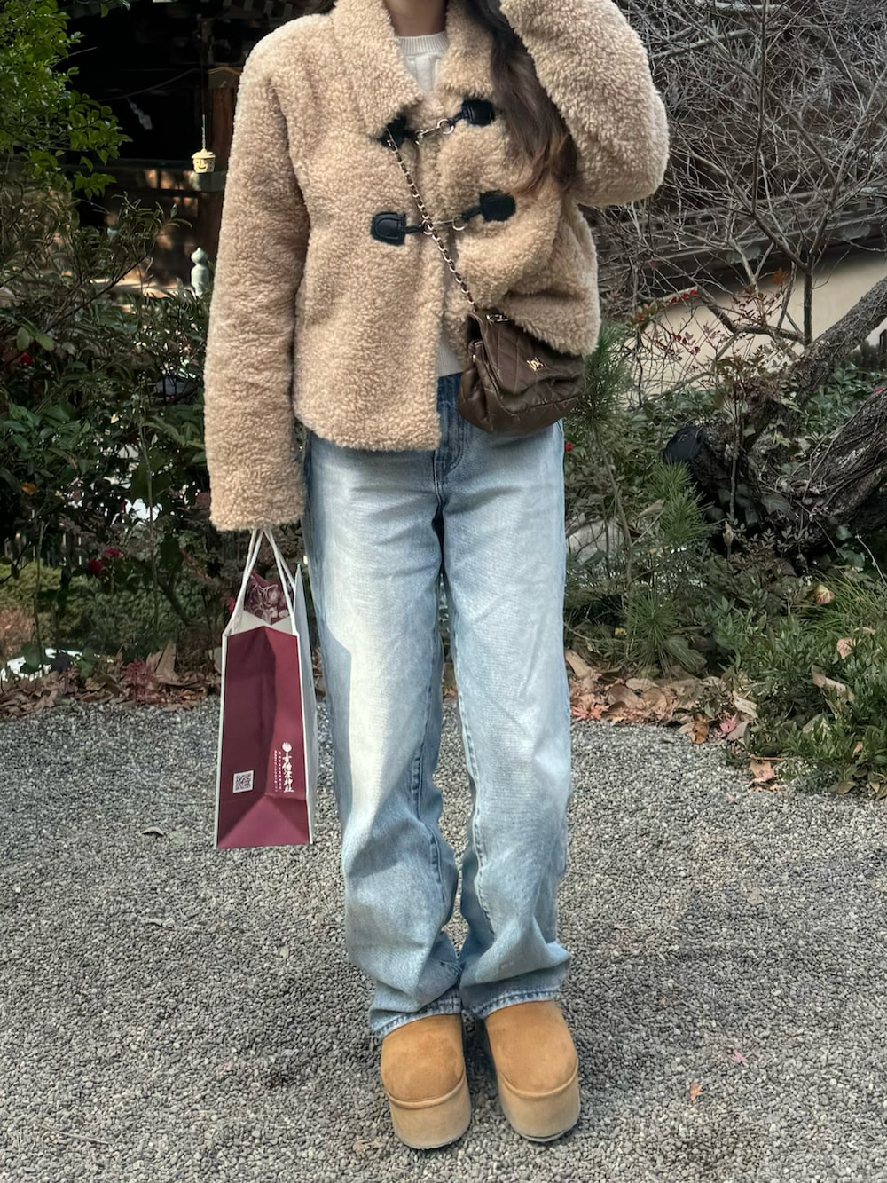 ベージュ系のジャケット/アウター、ブルー系のデニムパンツ、ブラウン系のブーツを着用したレディースの冬コーディネートの2枚目の写真