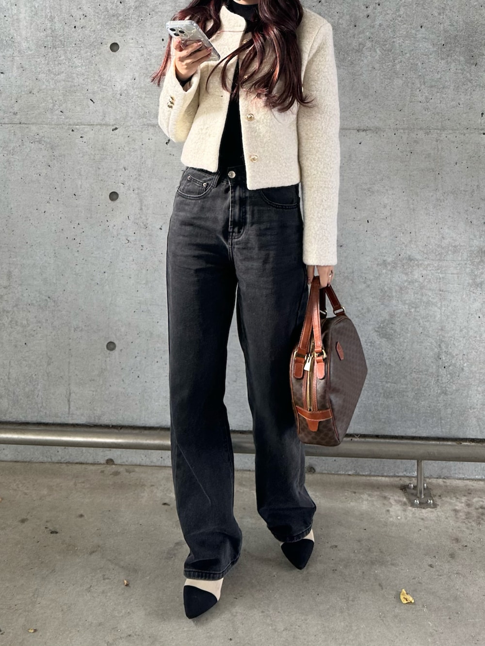 ホワイト系のジャケット/アウター、ブラック系のデニムパンツ、ブラウン系のバッグを着用したレディースの冬コーディネートの2枚目の写真