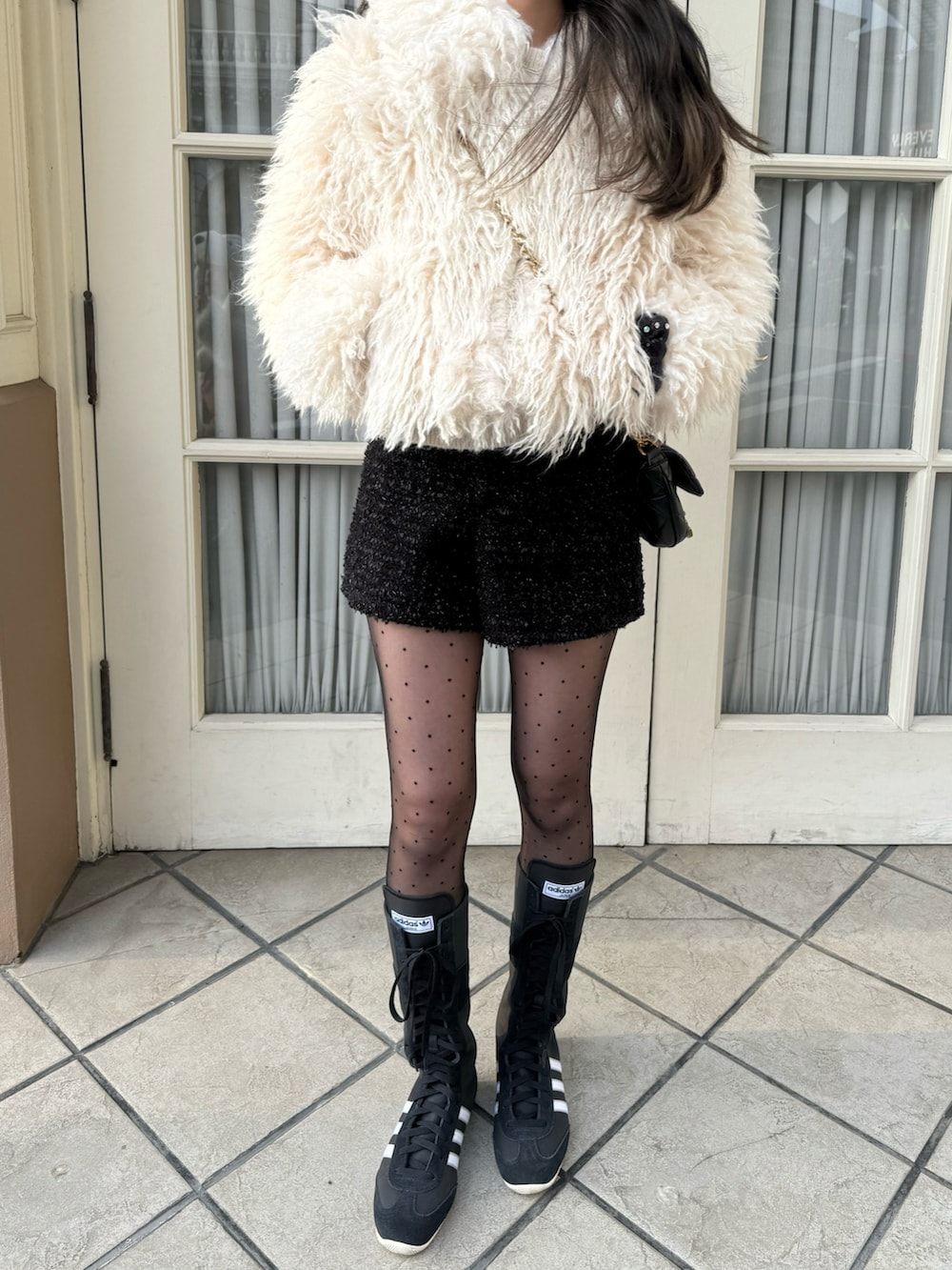 ホワイト系のジャケット/アウター、ブラック系のパンツ、ブラック系のスニーカーを着用したレディースの冬コーディネートの2枚目の写真