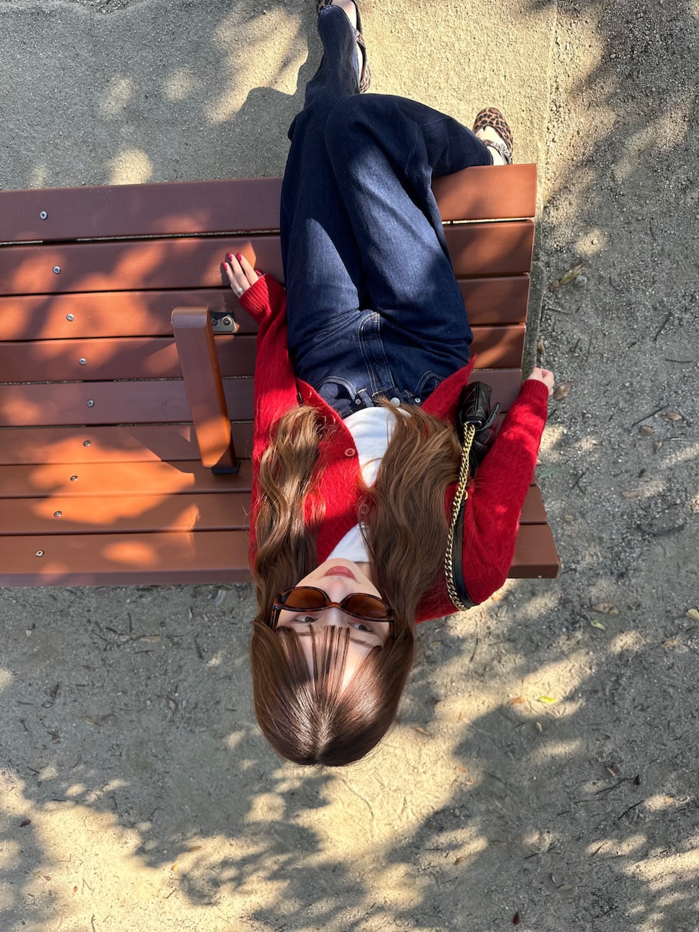 ホワイト系のTシャツ/カットソー、レッド系のカーディガン/ボレロ、ブルー系のデニムパンツを着用したレディースの秋コーディネートの3枚目の写真