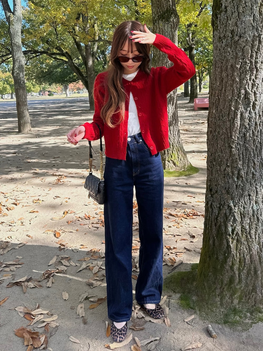 ホワイト系のTシャツ/カットソー、レッド系のカーディガン/ボレロ、ブルー系のデニムパンツを着用したレディースの秋コーディネートの2枚目の写真