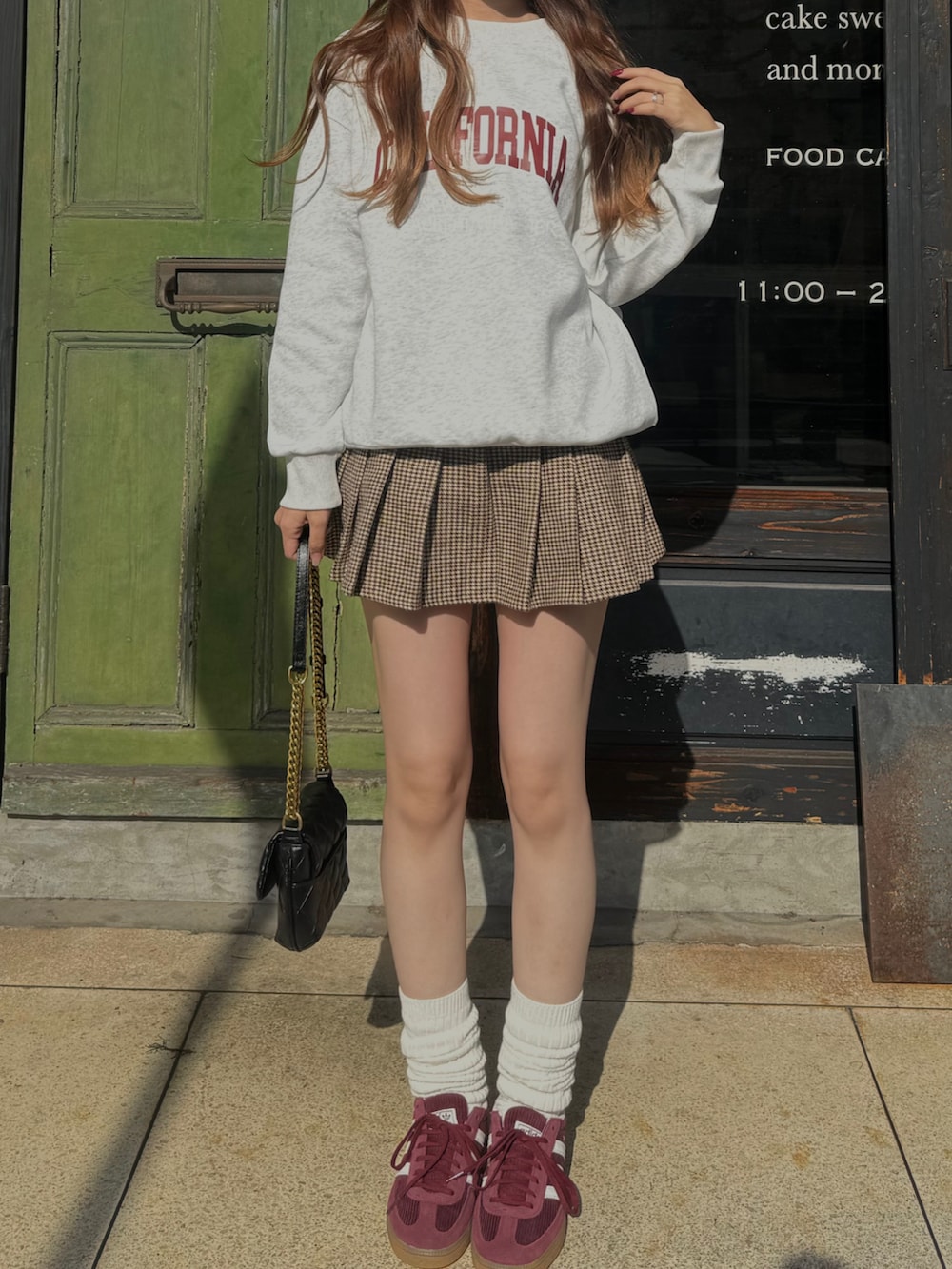 ピンク系のスニーカー、ブラック系のショルダーバッグ、グレー系のスウェットを着用したレディースの秋コーディネートの3枚目の写真