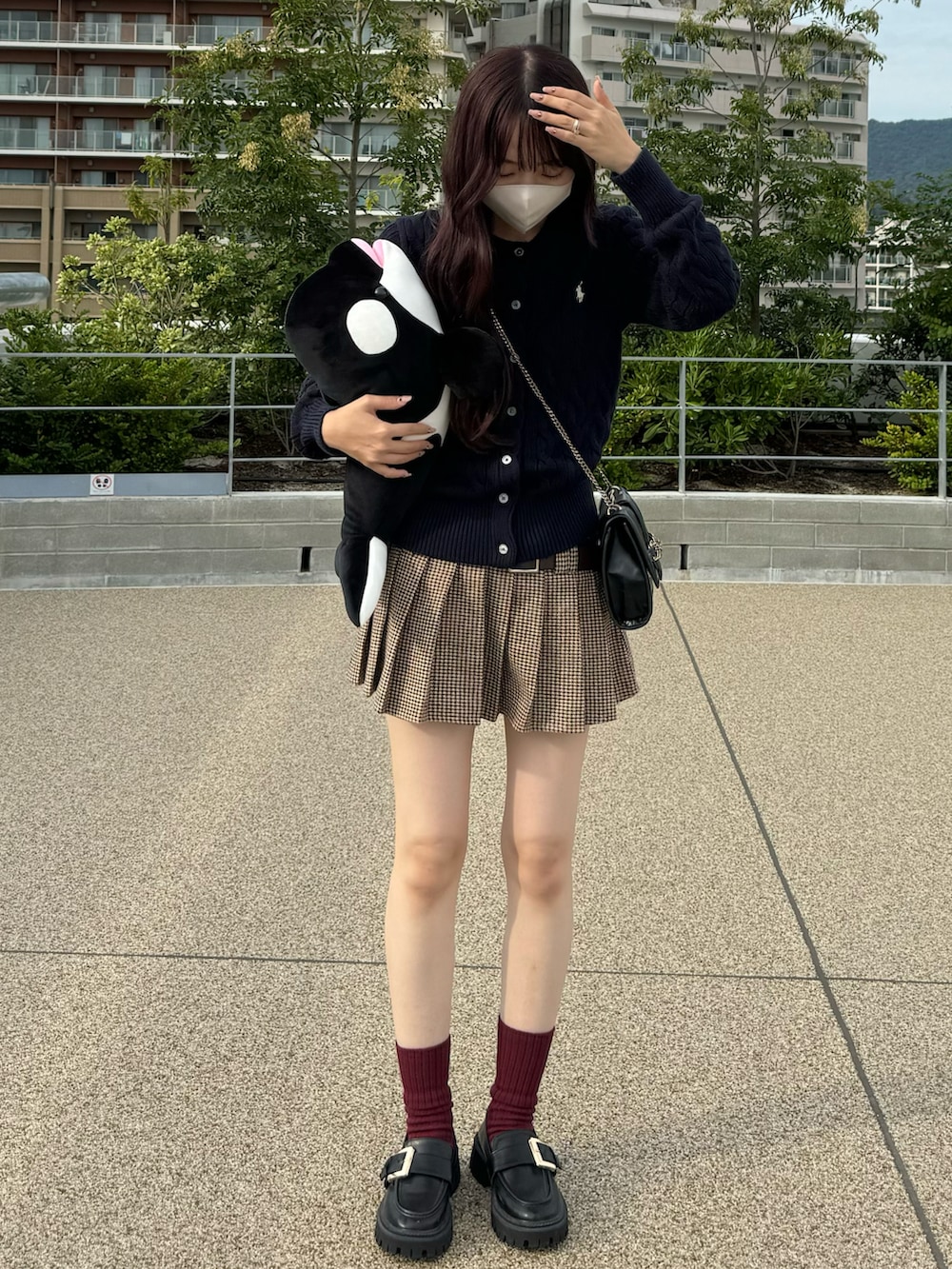 ブルー系のカーディガン/ボレロ、ブラウン系のスカート、ブラック系のローファーを着用したレディースの秋コーディネートの2枚目の写真