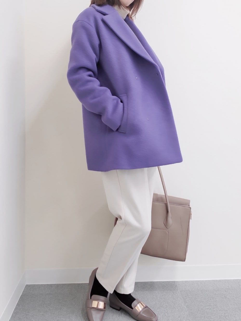 ベージュ系のビジネスバッグ、パープル系のステンカラーコート、グレー系のローファーを着用したレディースの冬コーディネートの3枚目の写真