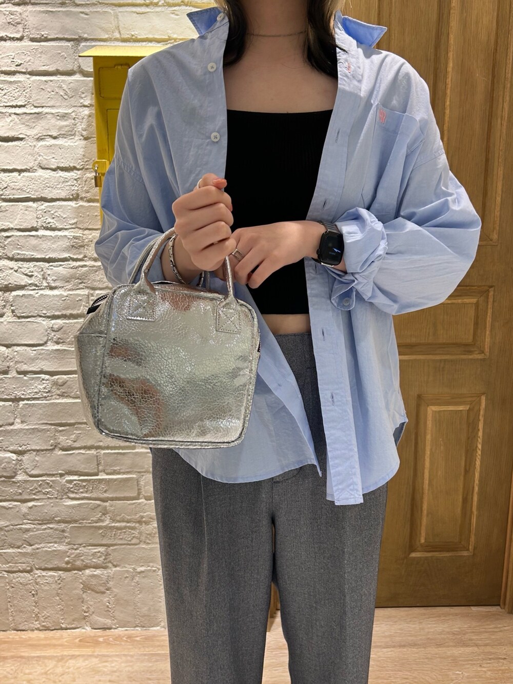 ブルー系のシャツ/ブラウス、ブルー系のスラックス、シルバー系のショルダーバッグを着用したレディースの冬コーディネートの2枚目の写真