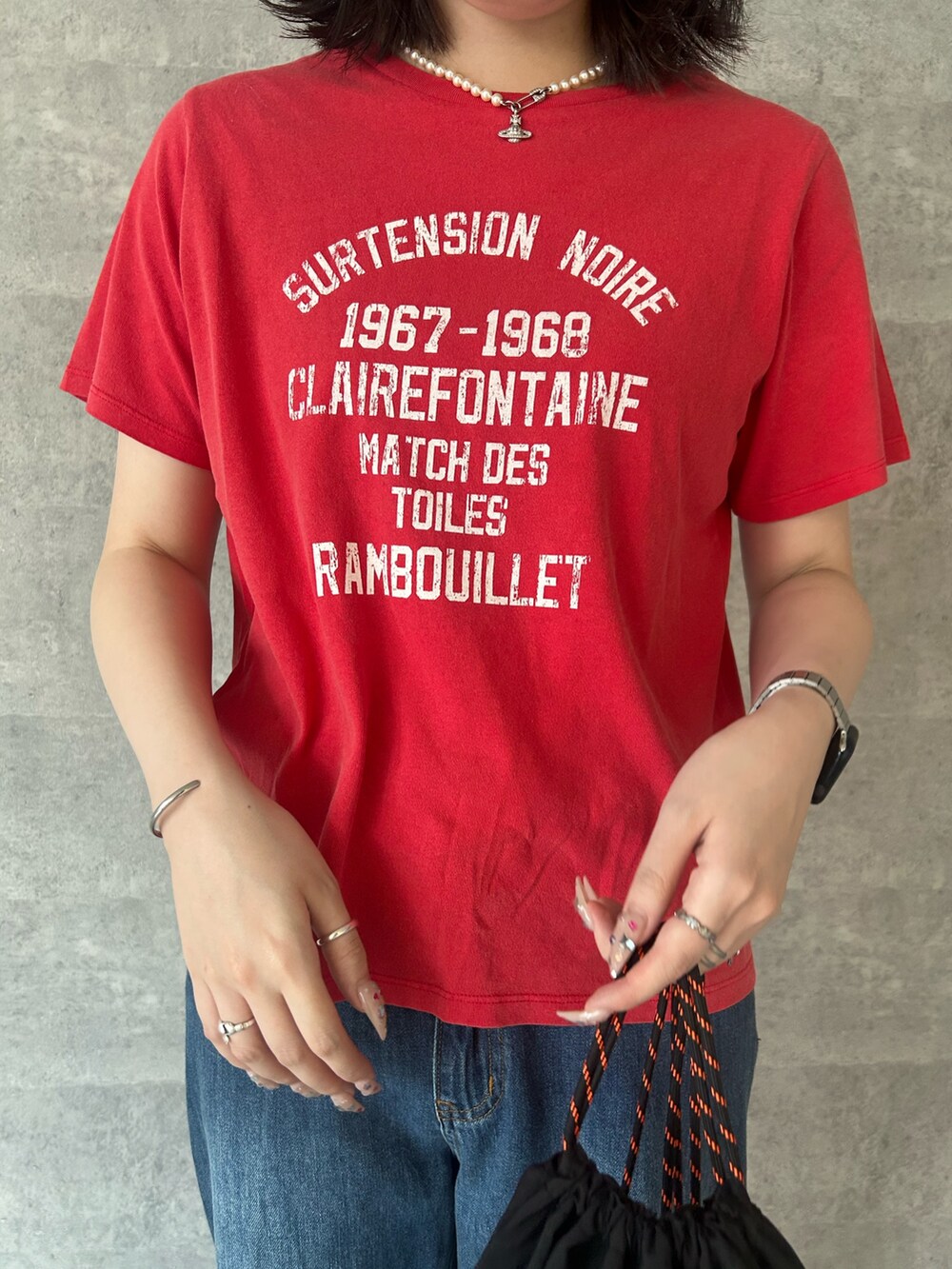 レッド系のTシャツ/カットソー、ブルー系のデニムパンツを着用したレディースの夏コーディネートの2枚目の写真