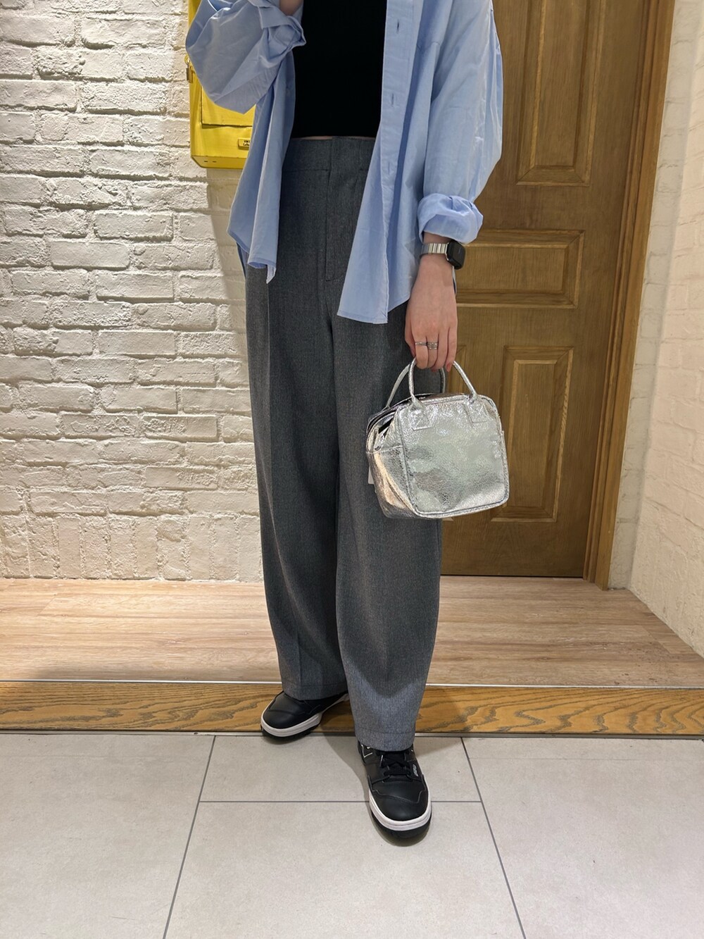 ブルー系のシャツ/ブラウス、ブルー系のスラックス、シルバー系のショルダーバッグを着用したレディースの冬コーディネートの3枚目の写真