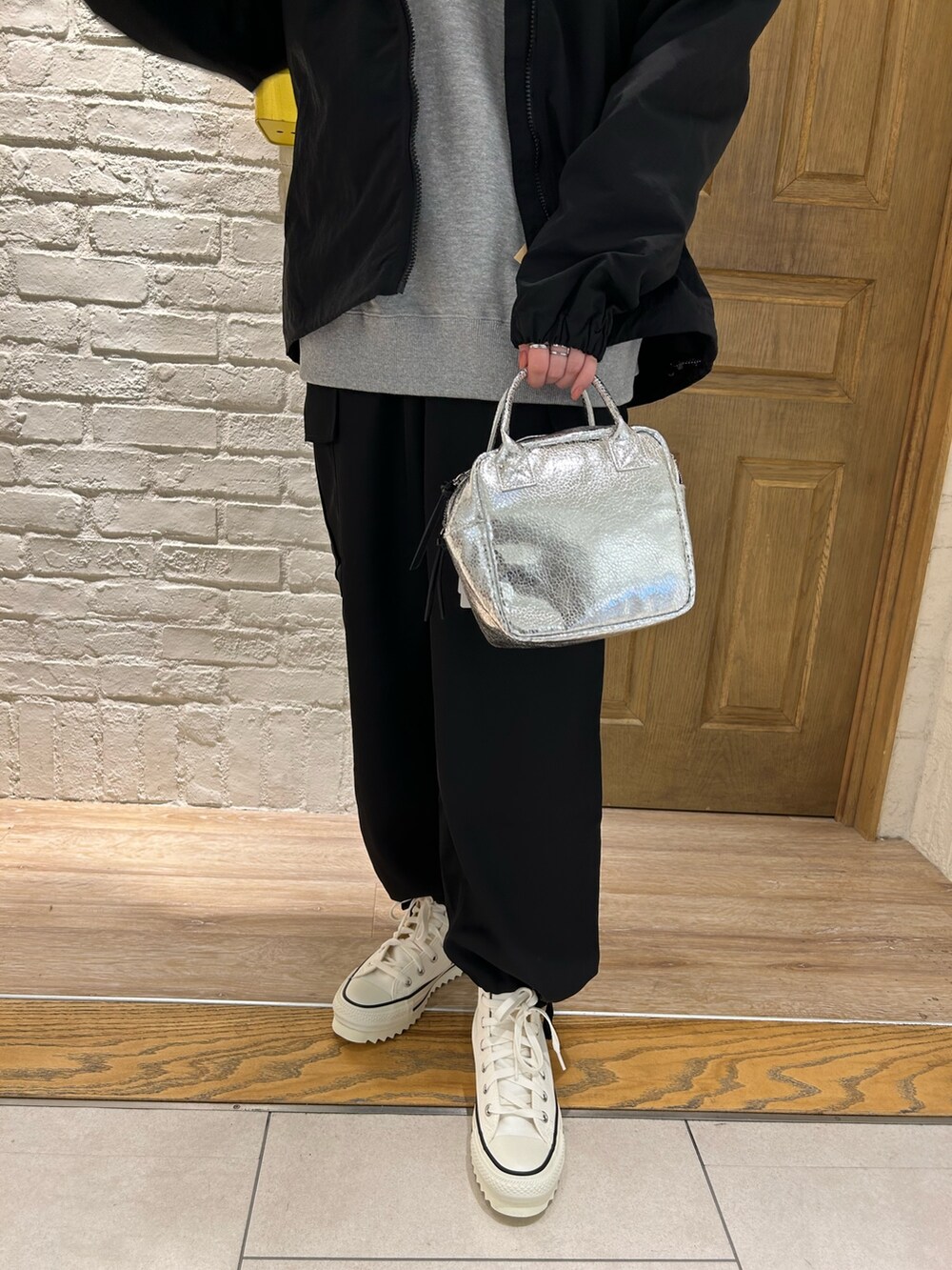 シルバー系のショルダーバッグ、ブラック系のその他パンツ、グレー系のスウェットを着用したレディースの冬コーディネートの3枚目の写真