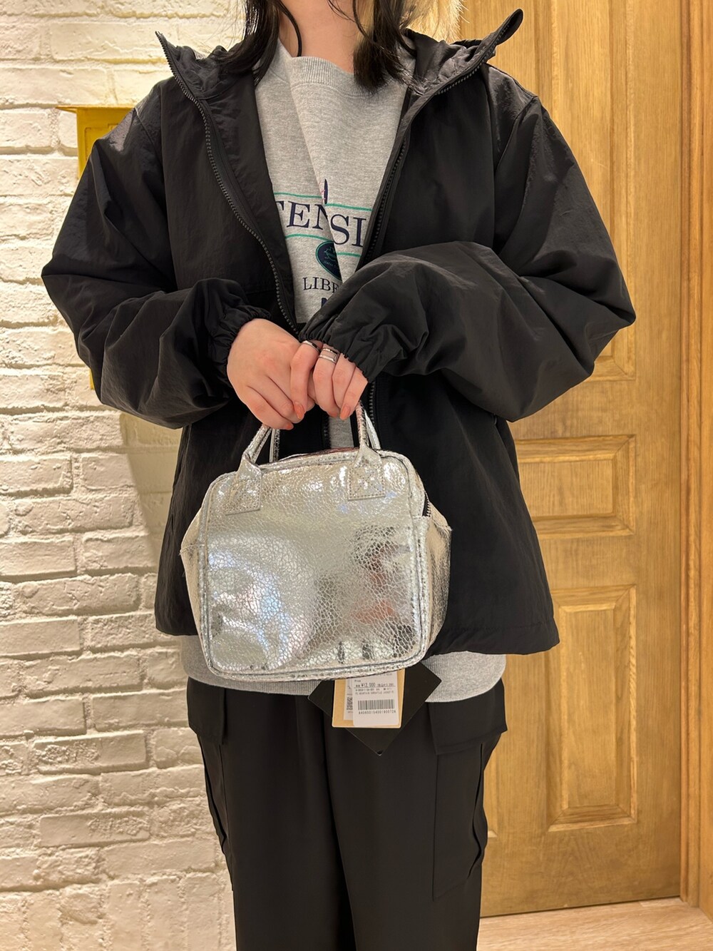 シルバー系のショルダーバッグ、ブラック系のその他パンツ、グレー系のスウェットを着用したレディースの冬コーディネートの2枚目の写真