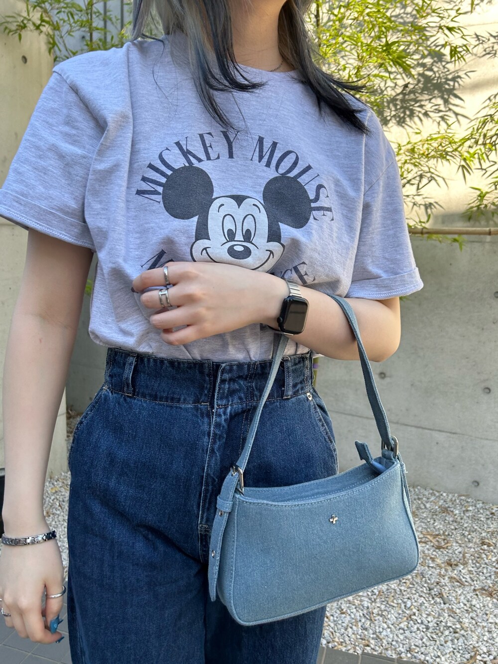 ブルー系のデニムパンツ、ブルー系のハンドバッグ、グレー系のTシャツ/カットソーを着用したレディースの夏コーディネートの2枚目の写真